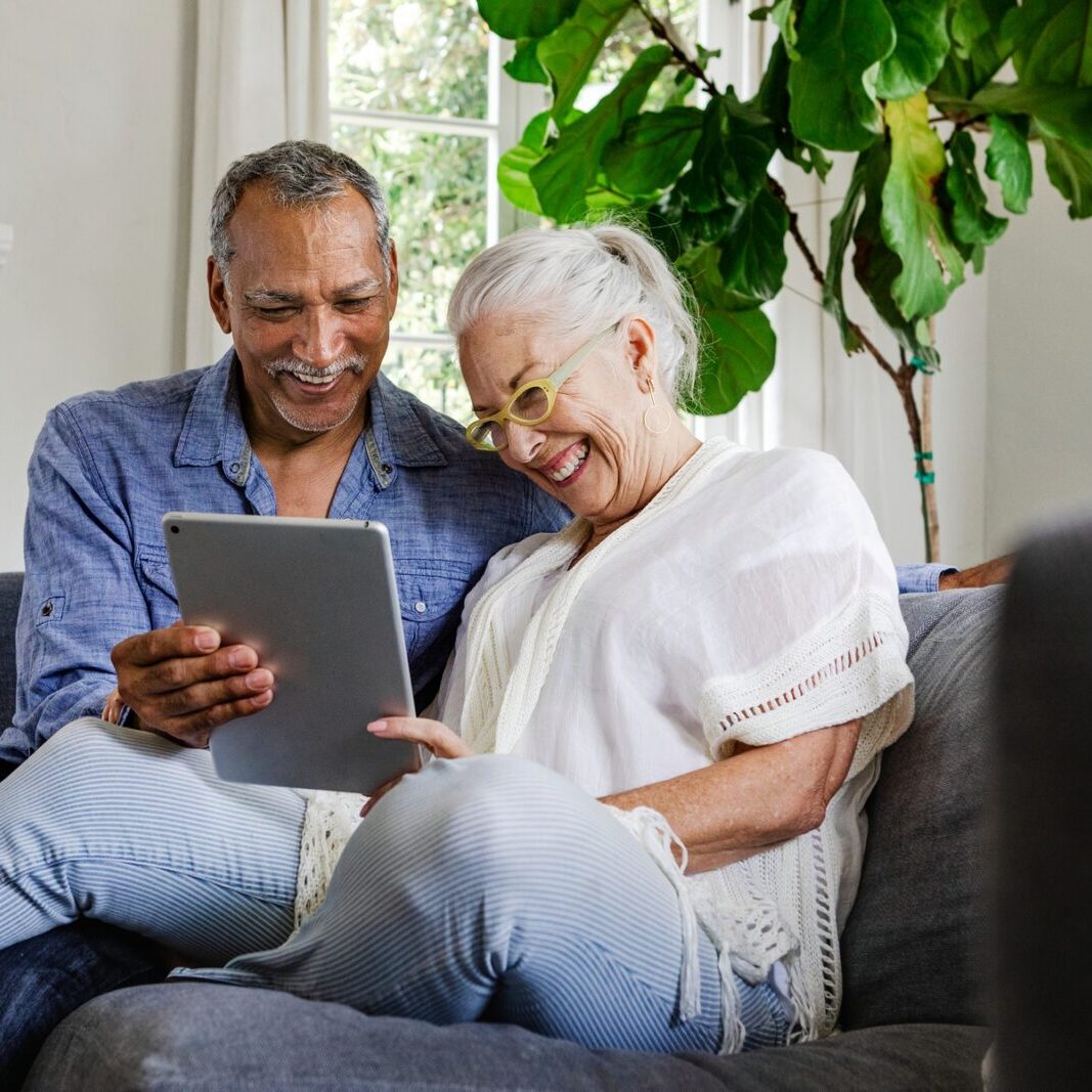 Elderly,Couple,Using,A,Tablet,On,A,Couch